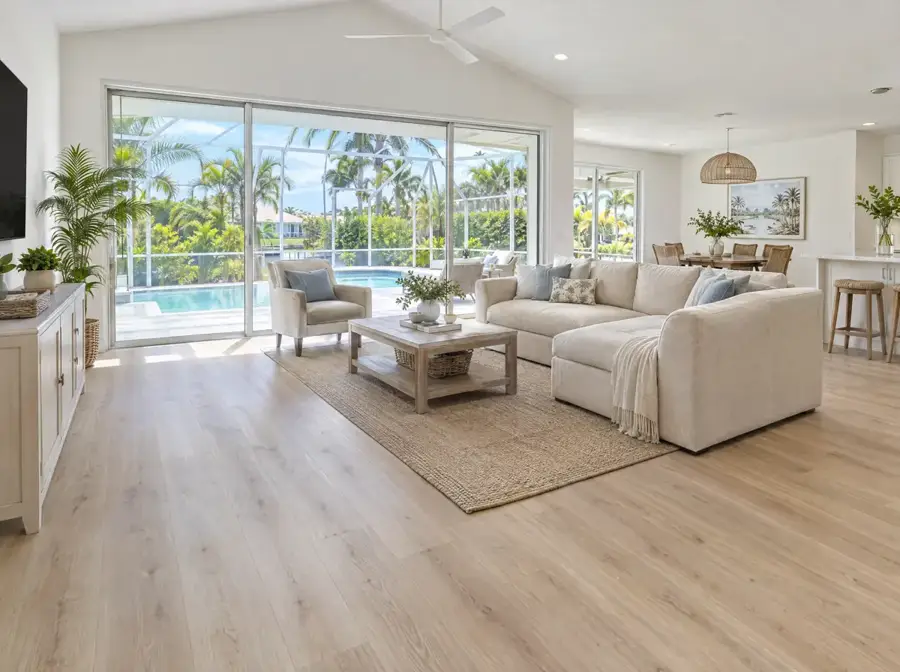 Florida great room with light oak vinyl plank flooring and sliders to a pool lanai