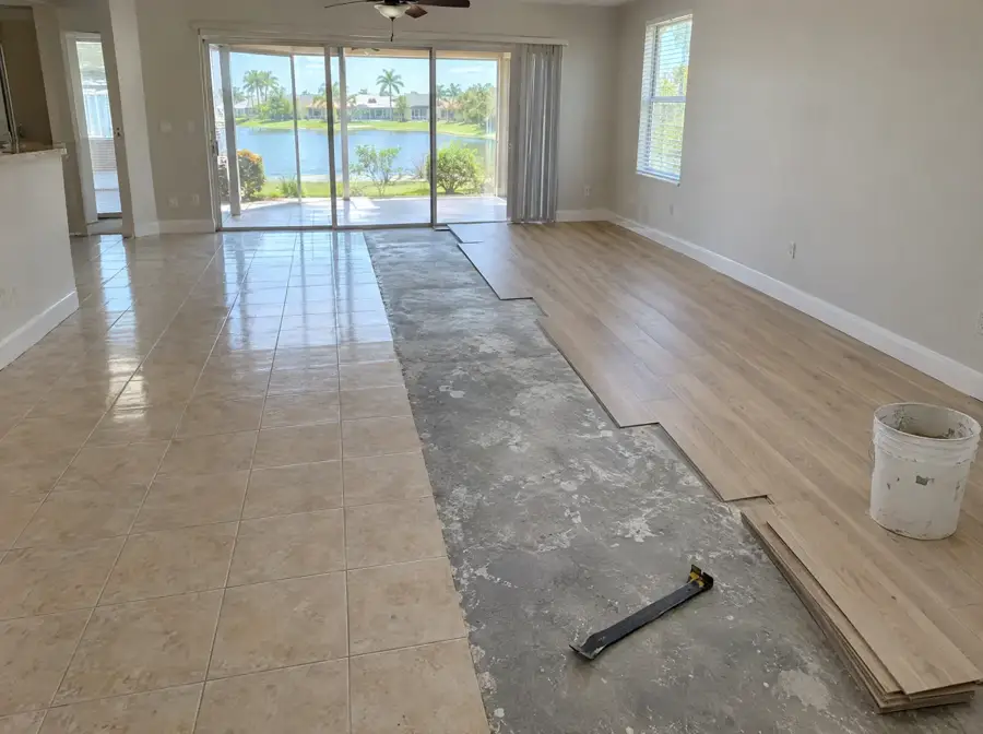 Florida living room with old ceramic tile half removed and new vinyl planks going down