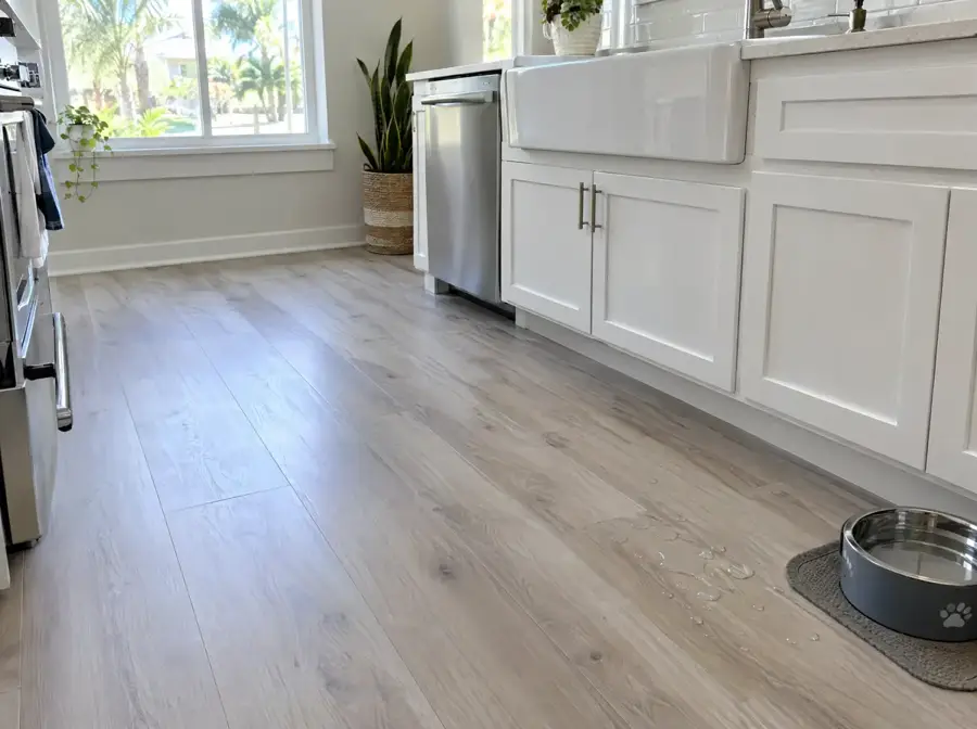 Driftwood grey waterproof vinyl plank in a Florida kitchen with water beading on the surface